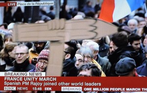 Marchers in Paris hold a giant pencil